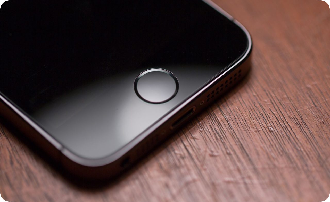 Close-up of an iPhone 5s home button: a circle set into the phone's rounded-rectangle body.